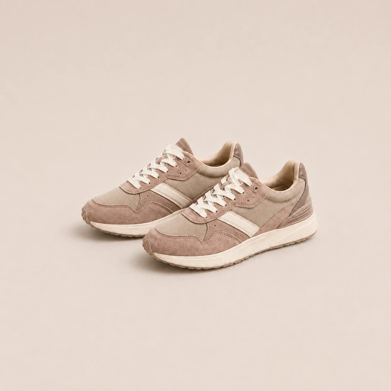 Pair of beige sneakers on a neutral studio background